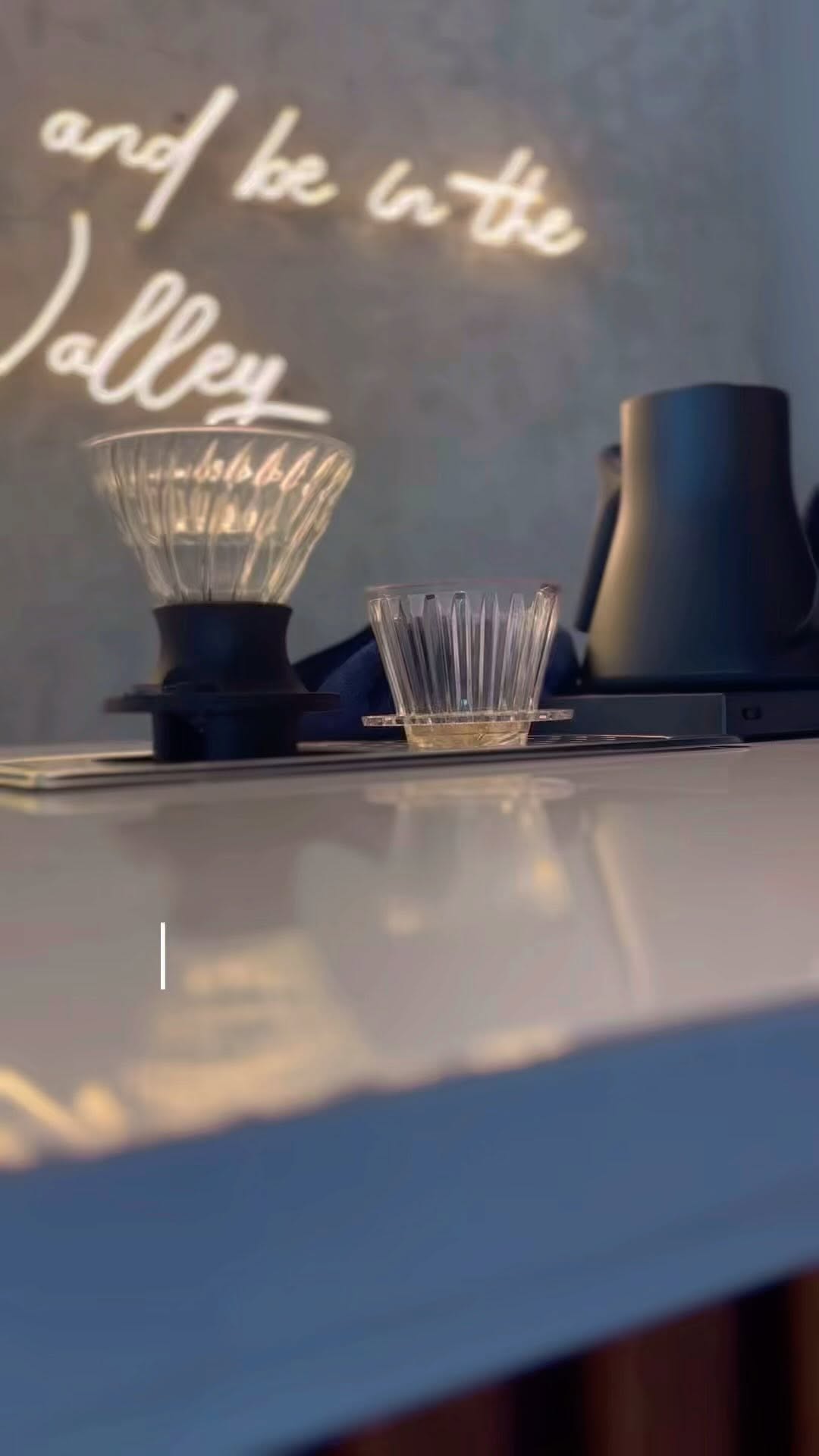 Happy Valley Café bar setup — neon Valley sign and pour-over equipment